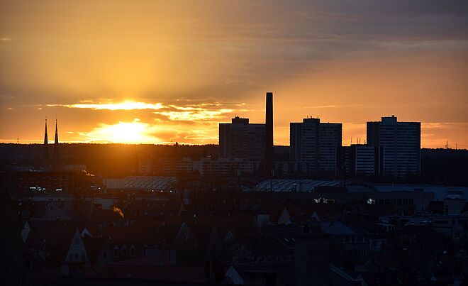 Luftaufnahme vom Industriegebiet in Augsburg. Im Hintergrund ist ein Sonnenuntergange