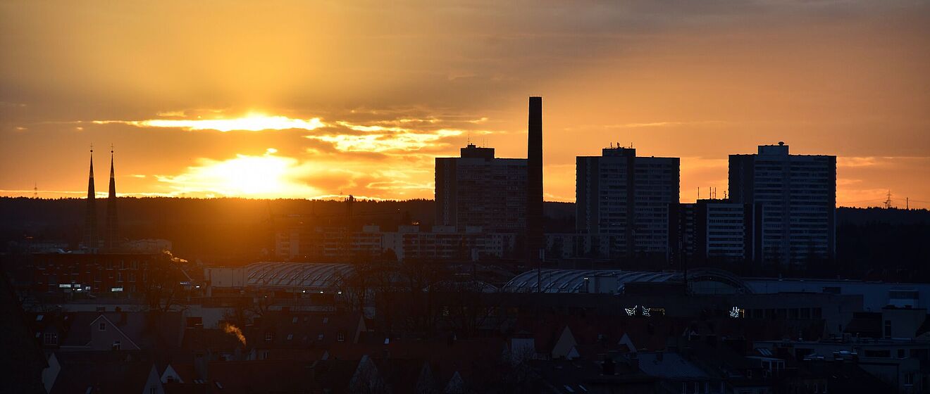 Luftaufnahme vom Industriegebiet in Augsburg. Im Hintergrund ist ein Sonnenuntergange