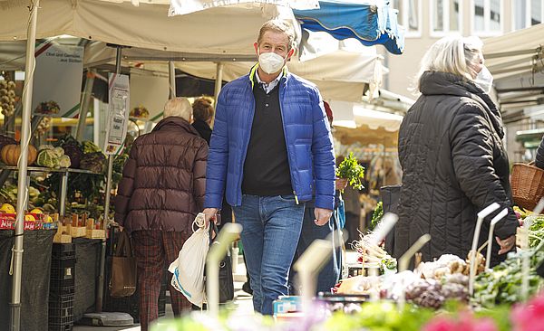 Personen beim Einkaufen, mit Einkaufstüten in den Händen.