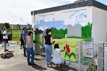 Personen besprühen mit Spraydosen ein Gebäude. - Ein Klick auf das Bild führt zur vergrößerten Fotoansicht.