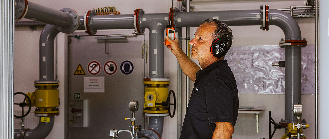 Mann misst Werte von Wasserinstalltionen im Keller