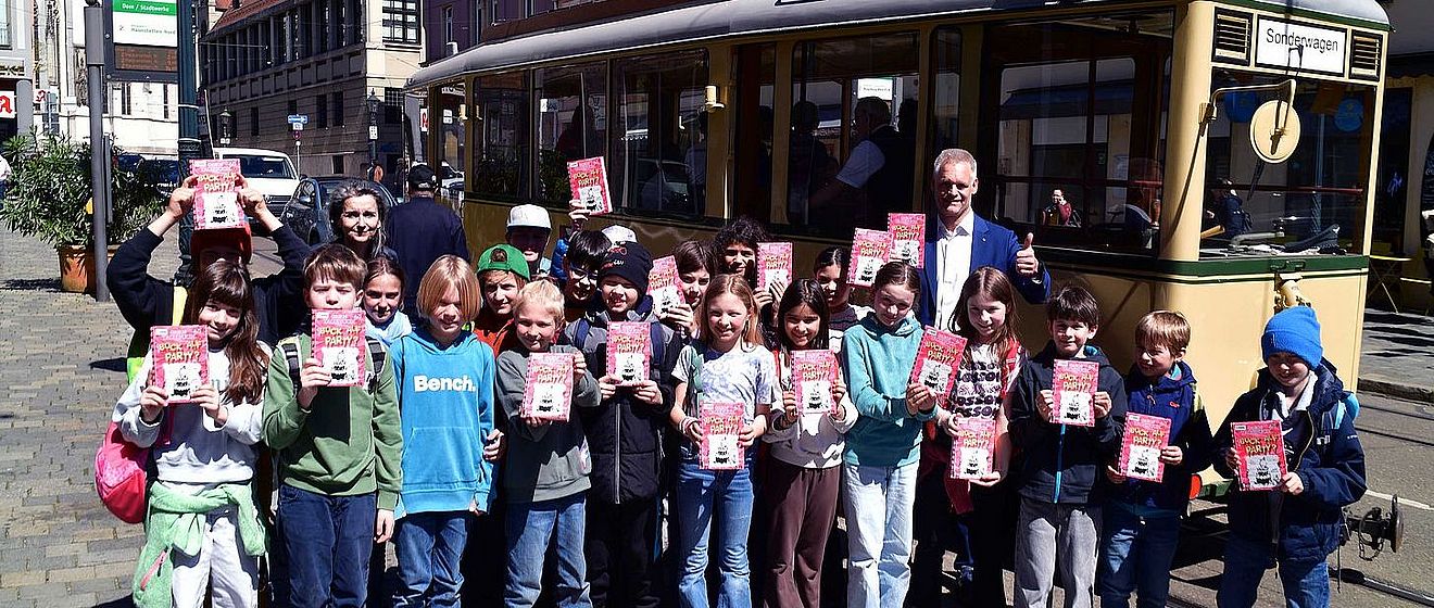 Kinder vor historischer Straßenbahn