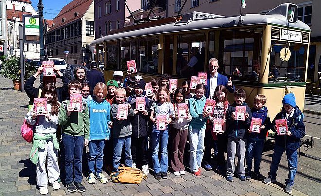 Kinder vor historischer Straßenbahn