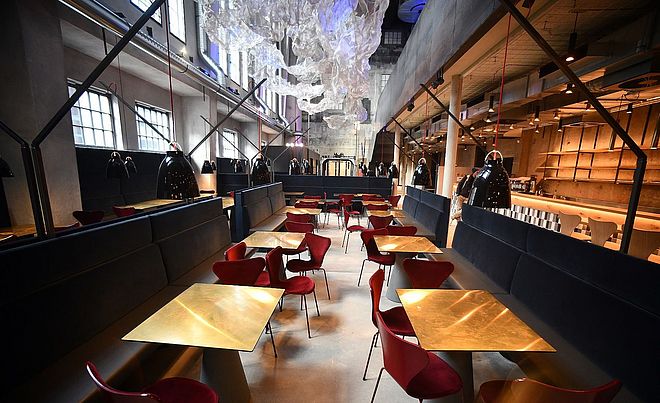 Tische mit Stühlen im Ofenhaus im Gaswerk. Weiterverlinkung auf German Design Award 2020 Newsartikel