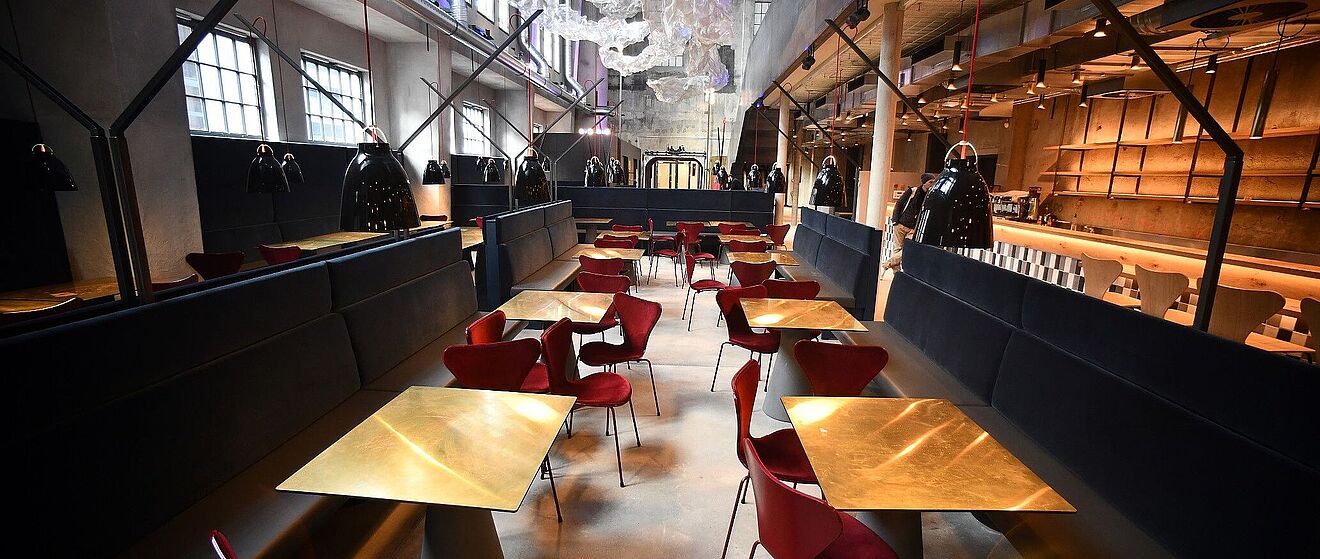 Tische mit Stühlen im Ofenhaus im Gaswerk.