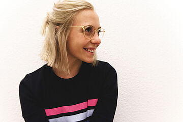 Nina Arnold, wie sie zur Seite schaut und lächelt. - Ein Klick auf das Bild führt zur vergrößerten Fotoansicht.