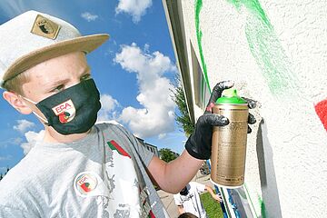 Kind sprüht mit Spray Dose, - Ein Klick auf das Bild führt zur vergrößerten Fotoansicht.