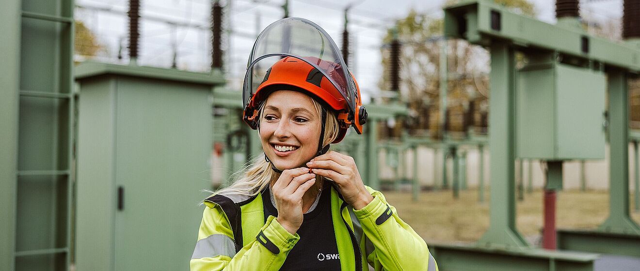 Frau mit Helm in der Netzeanlage. Weiterverlinkung zu swa Karriereseite