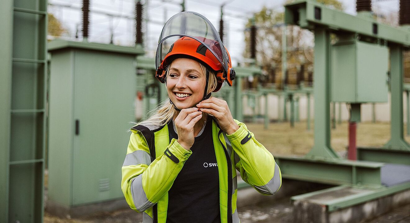 Frau mit Helm in der Netzeanlage. Weiterverlinkung zu swa Karriereseite
