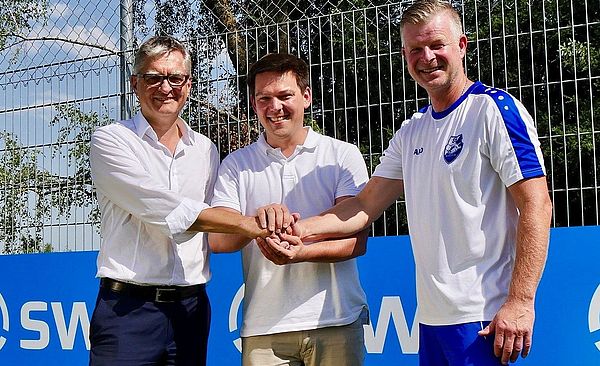 Spieler des SV-Bergheim und ein swa Mitarbeiter stehen nebeneinander und geben sich die Hand.