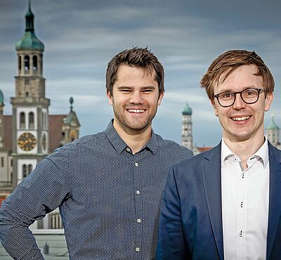 Dr. Florian Samweber und Daniel Lassahn und im Hintergrund der Rathausplatz.
