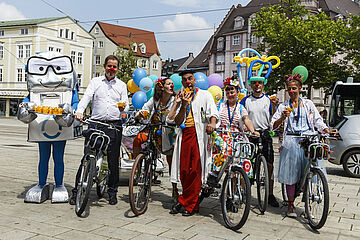 Klinikclowns mit Maskottchen und Fahrrädern in der Innenstadt. Ein Klick sorgt für eine Großansicht des Bildes.