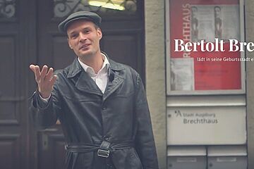 Schauspieler mit schwarzen Klamotten vor dem Brechthaus in Augsburg. Ein Klick sorgt für eine Großansicht des Bildes.