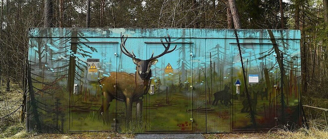 Graffiti eines Hirsches auf einem Stromhaus im Wald
