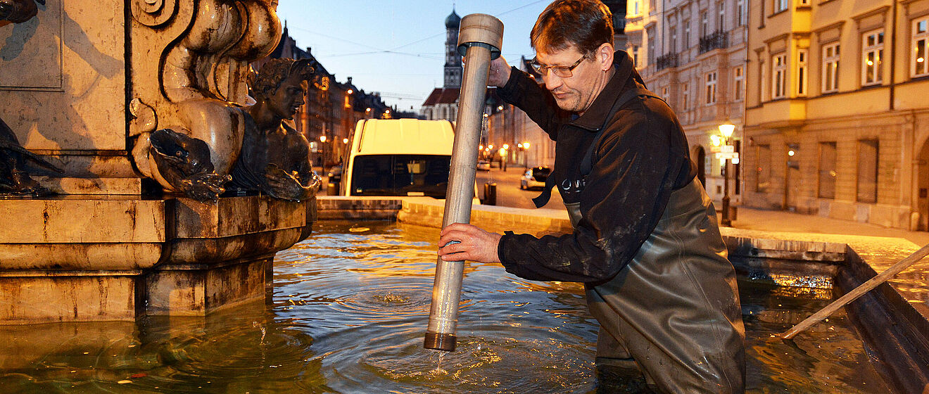 Ein Mitarbeiter der swa macht einen Brunnen winterfest.