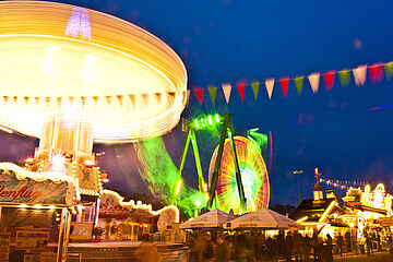 Menschen auf dem Augsburger Plärrer. Links ist ein Karussell und im Hintergrund ein Riesenrad. Ein Klick sorgt für eine Großansicht des Bildes.