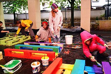 Kinder bemalen Paletten in bunten Farben.