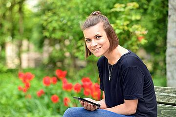 Frau lächelt in Kamera, - Ein Klick auf das Bild führt zur vergrößerten Fotoansicht.