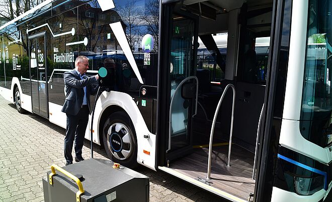 Mann im Anzug verbindet einen neuen swa eBus mit einer Ladebox. 