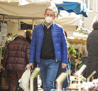 Header: Personen laufen auf dem Stadtmarkt
