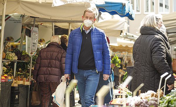 Header: Personen laufen auf dem Stadtmarkt