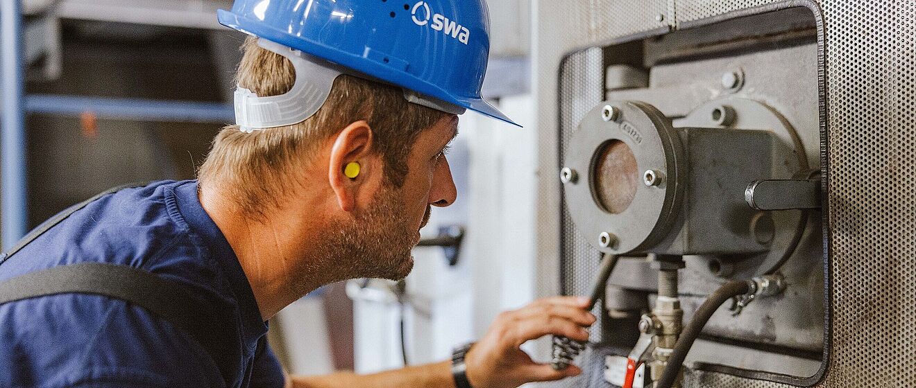 swa Mitarbeiter schaut in ein Ofenfenster