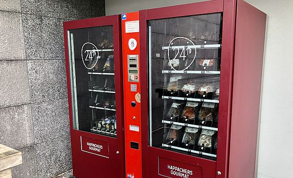 Zwei rote Automaten mit verschiedenen Lebensmitteln zum Grillen.