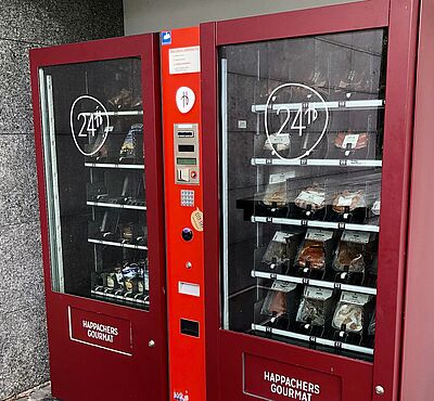 Zwei rote Automaten mit verschiedenen Lebensmitteln zum Grillen.