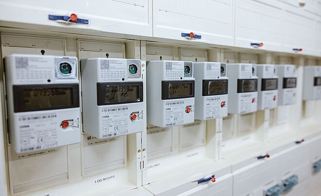 Mehrere Stromzähler mit Zählerständen in einem Keller