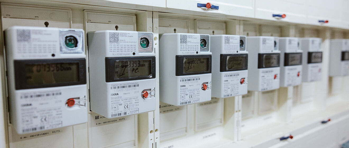 Mehrere Stromzähler mit Zählerständen in einem Keller