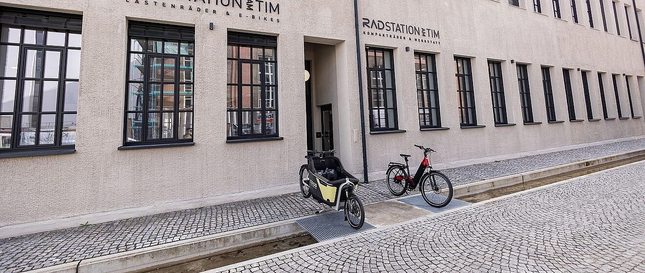 Lastenrad und Fahrrad auf der Straße vor der Radstation am TIM