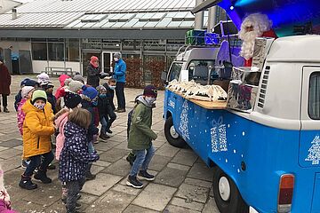 Nikolaus gibt Geschenk-Säcke an Kinder aus. - Ein Klick auf das Bild führt zur vergrößerten Fotoansicht.