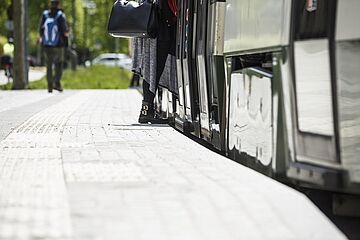 Eine Person steigt in eine Straßenbahn der swa ein. auf dem Boden sind Streifen für Barrierefreiheit zu erkennen. Ein Klick auf das Bild ermöglicht eine größere Ansicht.