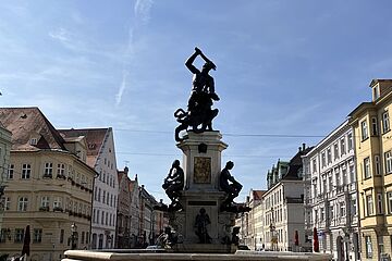 Herkulessbrunnen mit Häusern im Hintergrund