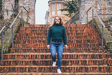 Eine junge Dame läuft an der Stadtmauer am Fischertor Treppen hinunter. - Ein Klick auf das Bild führt zur vergrößerten Fotoansicht.