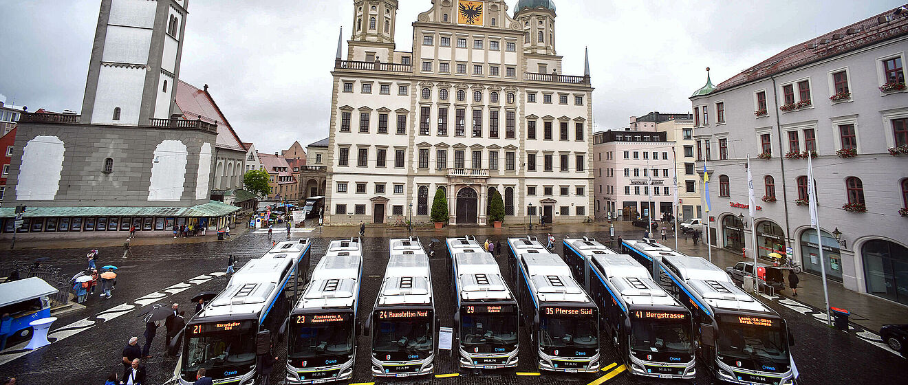 Luftaufnahme der neuen swa Busse, die aufgereiht auf dem Augsburger Rathausplatz stehen