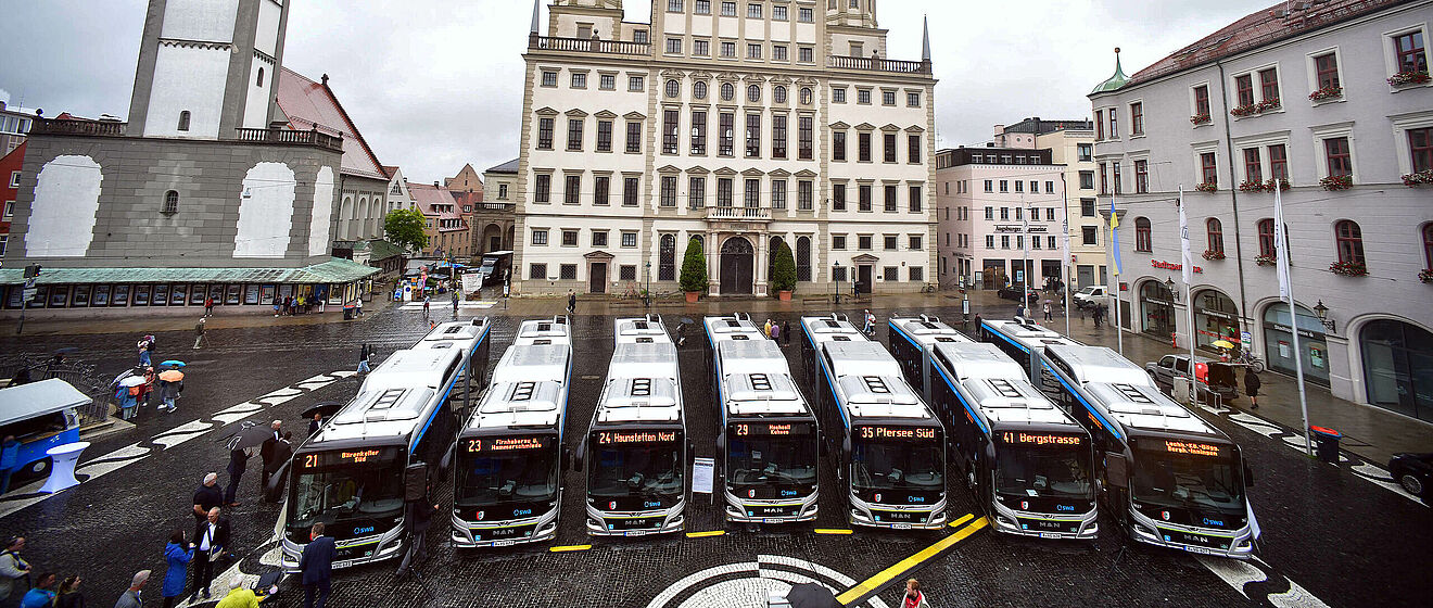 Luftaufnahme der neuen swa Busse, die aufgereiht auf dem Augsburger Rathausplatz stehen