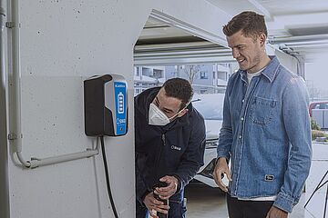 Finnbogason und ein swa Mitarbeiter betrachten eine Wallbox. - Ein Klick auf das Bild führt zur vergrößerten Fotoansicht