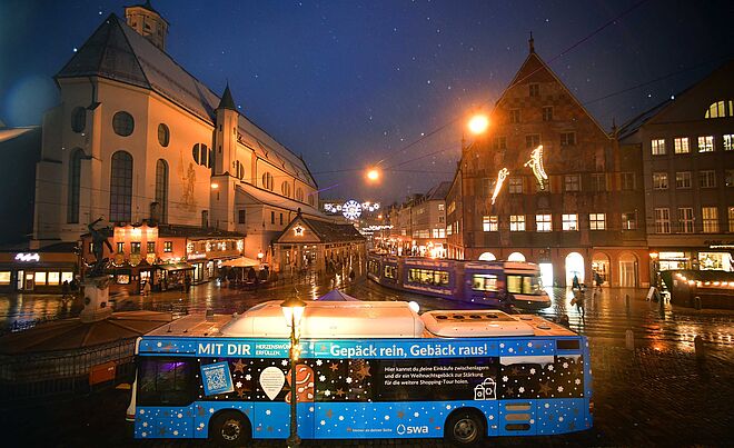 swa Bus mit Herzenswunsch Branding steht vor dem weihnachtlich geschmückten Moritzplatz. Im Hintergrund ist eine Straßenbahn