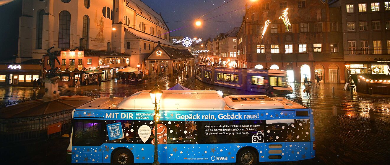 swa Bus mit Herzenswunsch Branding steht vor dem weihnachtlich geschmückten Moritzplatz. Im Hintergrund ist eine Straßenbahn
