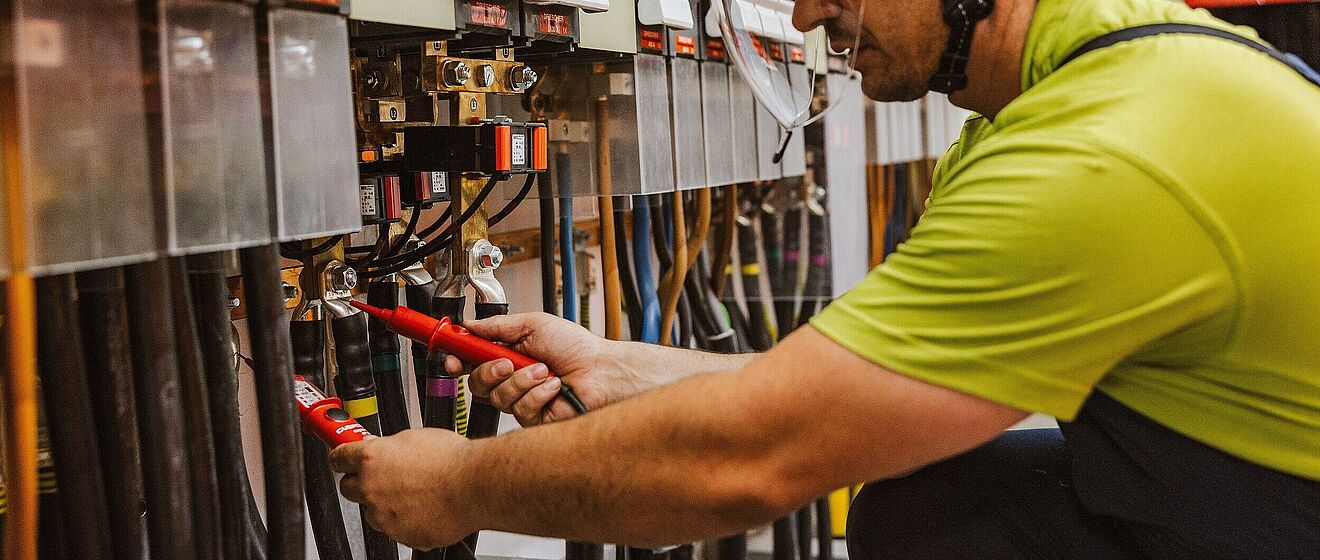 swa Netze Mitarbeiter misst die Spannung. Link zum Öffnen eines Pop-Ups mit Informationen zu Planung & Bau von Schaltanlagen und Transformatorenstationen