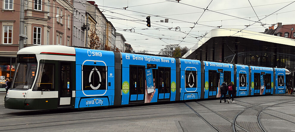 Straßenbahn mit swa City Branding im Hintergrund ist die Haltestelle Königsplatz