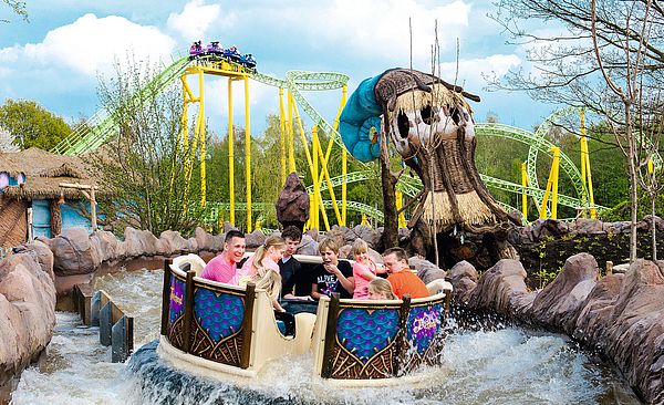 Familie, die im Freizeitpark mit einer Wasserachterbahn fährt.