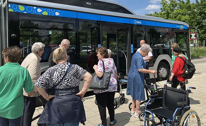 Senioren stehen neben Bus