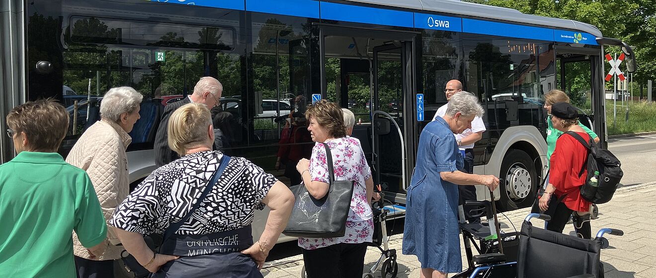 Senioren stehen neben Bus