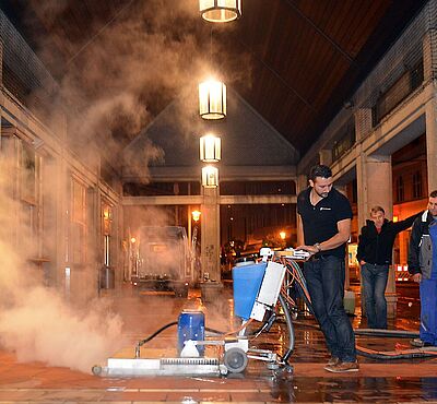 Männer reinigen Steine am Moritzplatz.