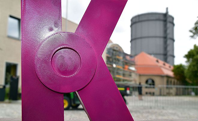 Pinke Kunstskulptur in Form eines K vor dem Gaswerk. Weiterverlinkung auf Bayerischer Staatspreis für Kreativorte Newsartikel