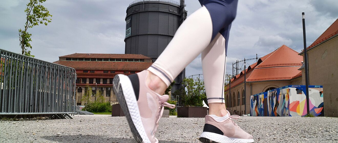 Nahaufnahme von Laufschuhen einer Person. Die Person läuft auf dem Gaswerksgelände in Augsburg