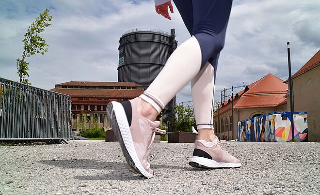 Nahaufnahme von Laufschuhen einer Person. Die Person läuft auf dem Gaswerksgelände in Augsburg