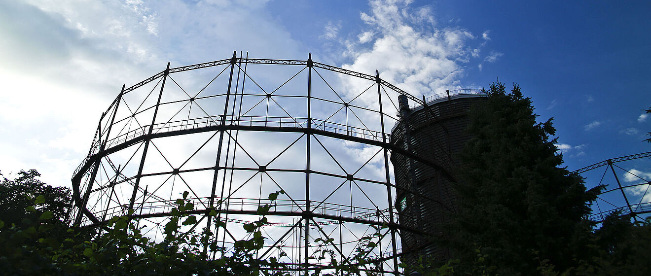 Gaswerk Augsburg mit einem Baum im Vodergrund. Link zum Öffnen eines Pop-Ups mit Informationen zu Netz- und Anlagenservice Erdgas